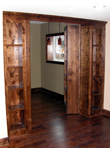 Cabinets conceal a home office with hinged bookcases